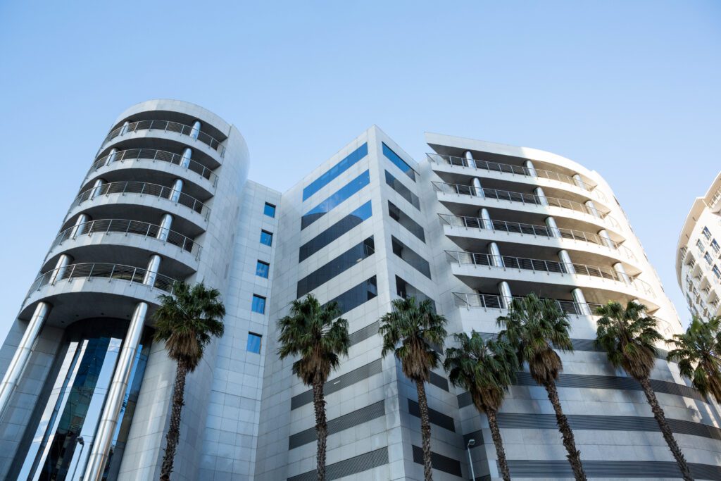 Investir dans l’immobilier à Tanger : Opportunités, Rentabilité et Conseils 8 Immeuble moderne représentant l’investissement immobilier, avec une architecture élégante et un ciel dégagé en arrière-plan, symbolisant la rentabilité et la croissance du patrimoine immobilier.